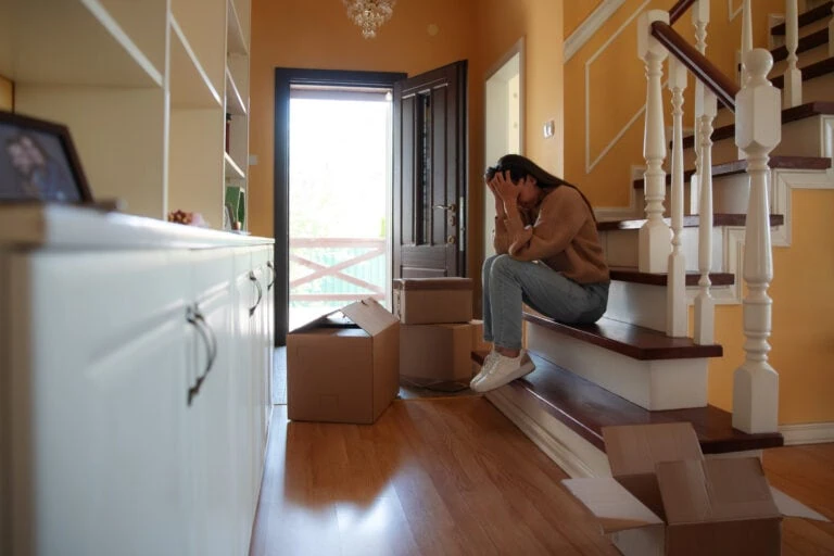 divorce real estate specialist, sad woman sitting on stairs selling home