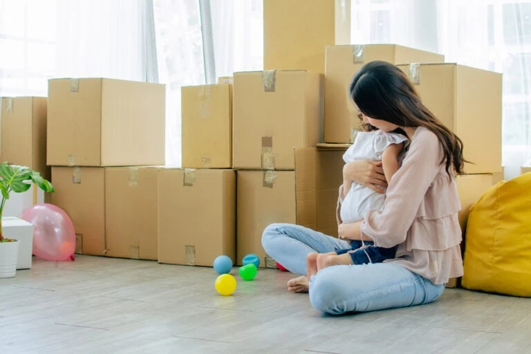 divorce settlement real estate, mother and daughter sitting with moving boxes