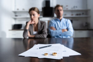 divorce real estate questions, divorcing couple sitting with rings and paperwork on table