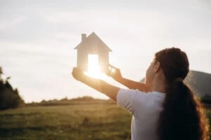 college investment property, child holding up paper house to the sunshine