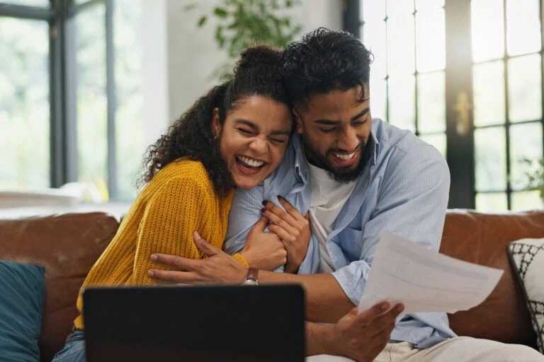 mortgage recast, happy couple excited about new home looking at paperwirk